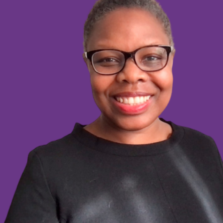 Professional headshot of Jacqui Manning smiling and wearing glasses and a black top, against a purple background.