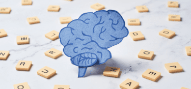 Image of hand drawn brain with scrabble letter pieces in the background to represent dyslexia