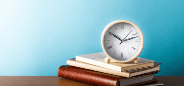 Blue background with picture of clock and pile of books