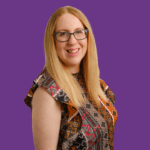 Zoe Farmer smiling in a professional portrait against a purple background, wearing glasses and a patterned sleeveless top.