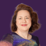 Profile pictire of Briony Craig, smiling at camera, wearing a blue patterned top
