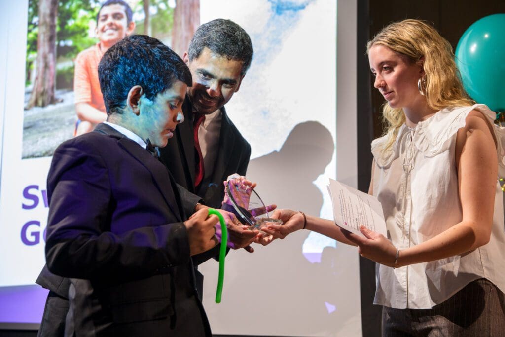 Image of Swarit Gopalan and his father accepting his award for ND young achiever of the year from Kirsty Campbell.