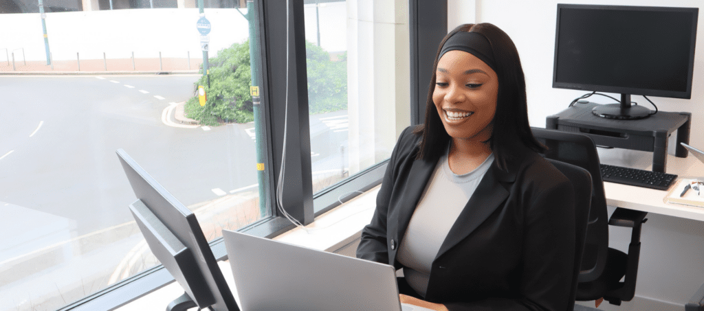 A person taking the Genius Finder on a laptop and smiling