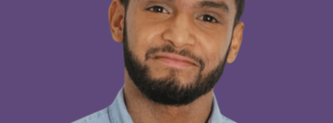 Afsar Ali smiling at the camera, wearing a light blue shirt.