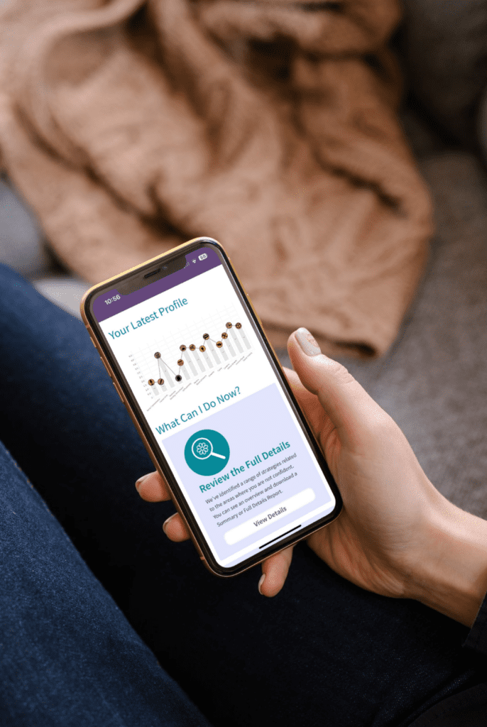 Image shows a persons hand holding a mobile phone. On the screen is an image of their profile on the Genius Finder platform