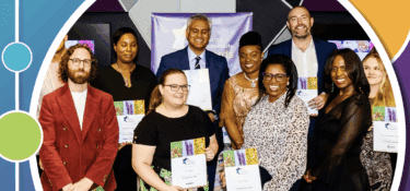 Image shows 9 individuals standing and smiling towards the camera. They mostly hold certificates in their hands showing them towards the camera
