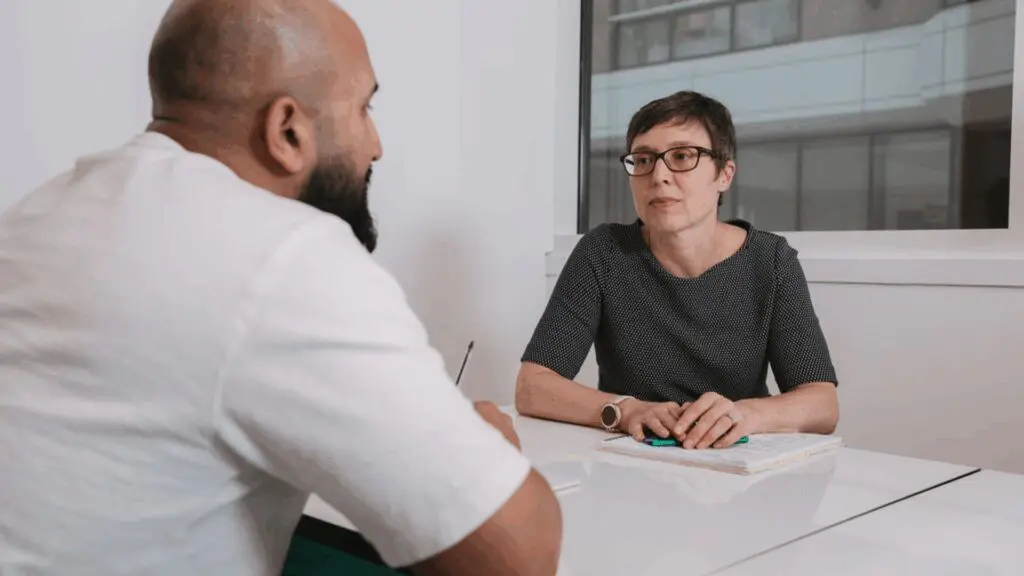 Two people talking at a table during recruitment process