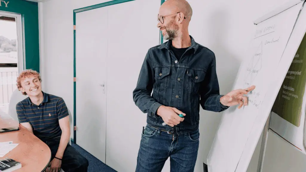 two professional people working at a white board