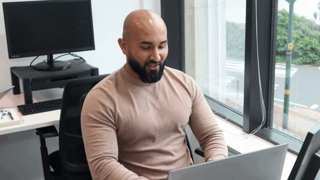 A person working at a desktop by a window