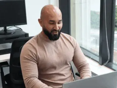 A person working at a desktop by a window