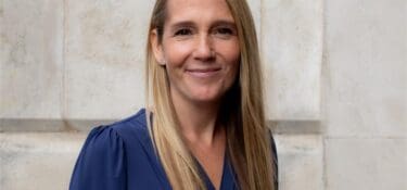 Blonde woman wearing a navy blue blouse.