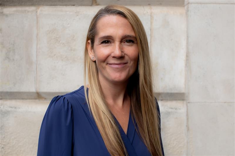 Blonde woman wearing a navy blue blouse.