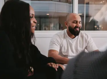 two people sitting and smiling.