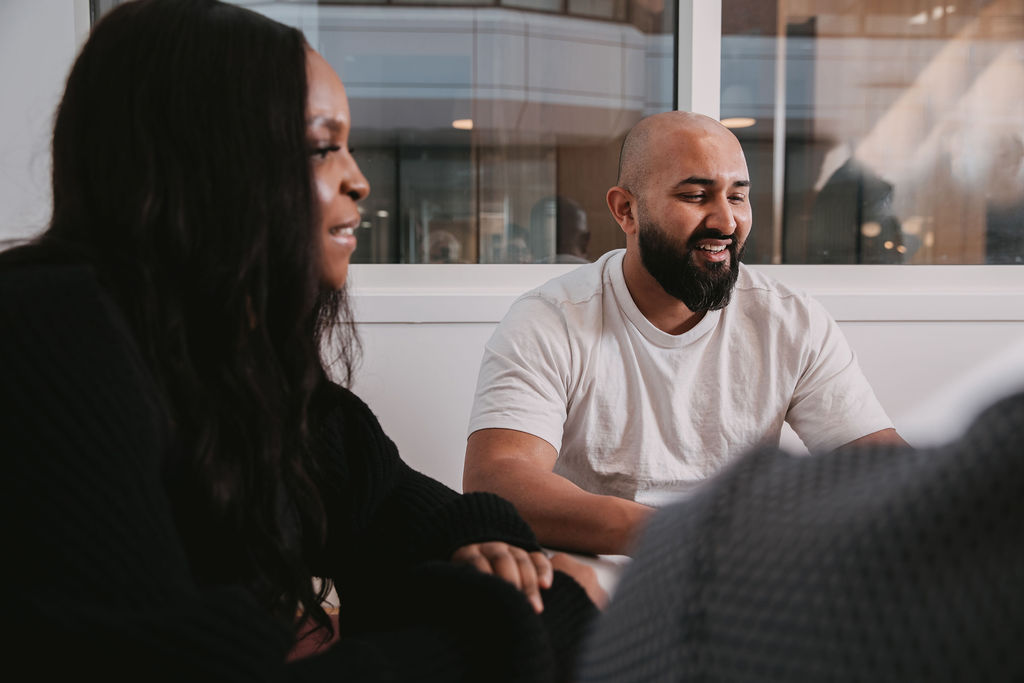 two people sitting and smiling.