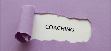 purple paper torn away to reveal the word coaching