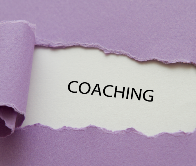 purple paper torn away to reveal the word coaching