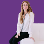 Portrait of Jasmine Navarro seated on a white chair, smiling warmly at the camera. She has long wavy light brown hair and is wearing a white blouse with black trim and black trousers. The background is solid purple, creating a bright, professional headshot.