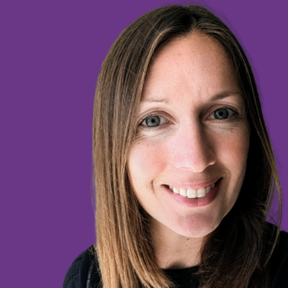 Head-and-shoulders portrait of Stephanie Benfield smiling at the camera. She has long straight brown hair parted to one side and is wearing a black top. The background is solid purple, creating a clean, professional headshot.