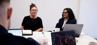 Nancy Doyle and Gunjan Odedra sitting in a psychology team meeting