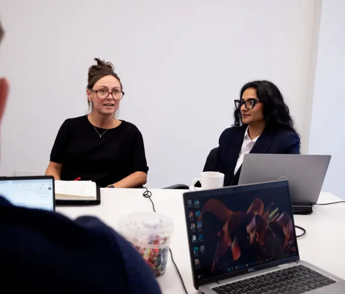 Nancy Doyle and Gunjan Odedra sitting in a psychology team meeting