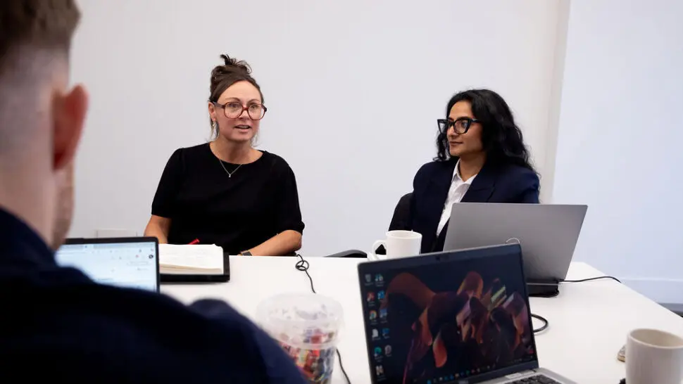 Nancy Doyle and Gunjan Odedra sitting in a psychology team meeting
