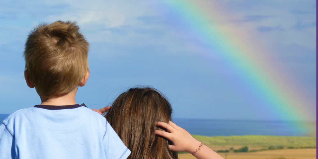 two kids looking at a rainbow