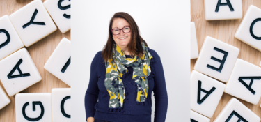 photo of Jacqui Wallis with letter tiles in the background to signify Dyslexia