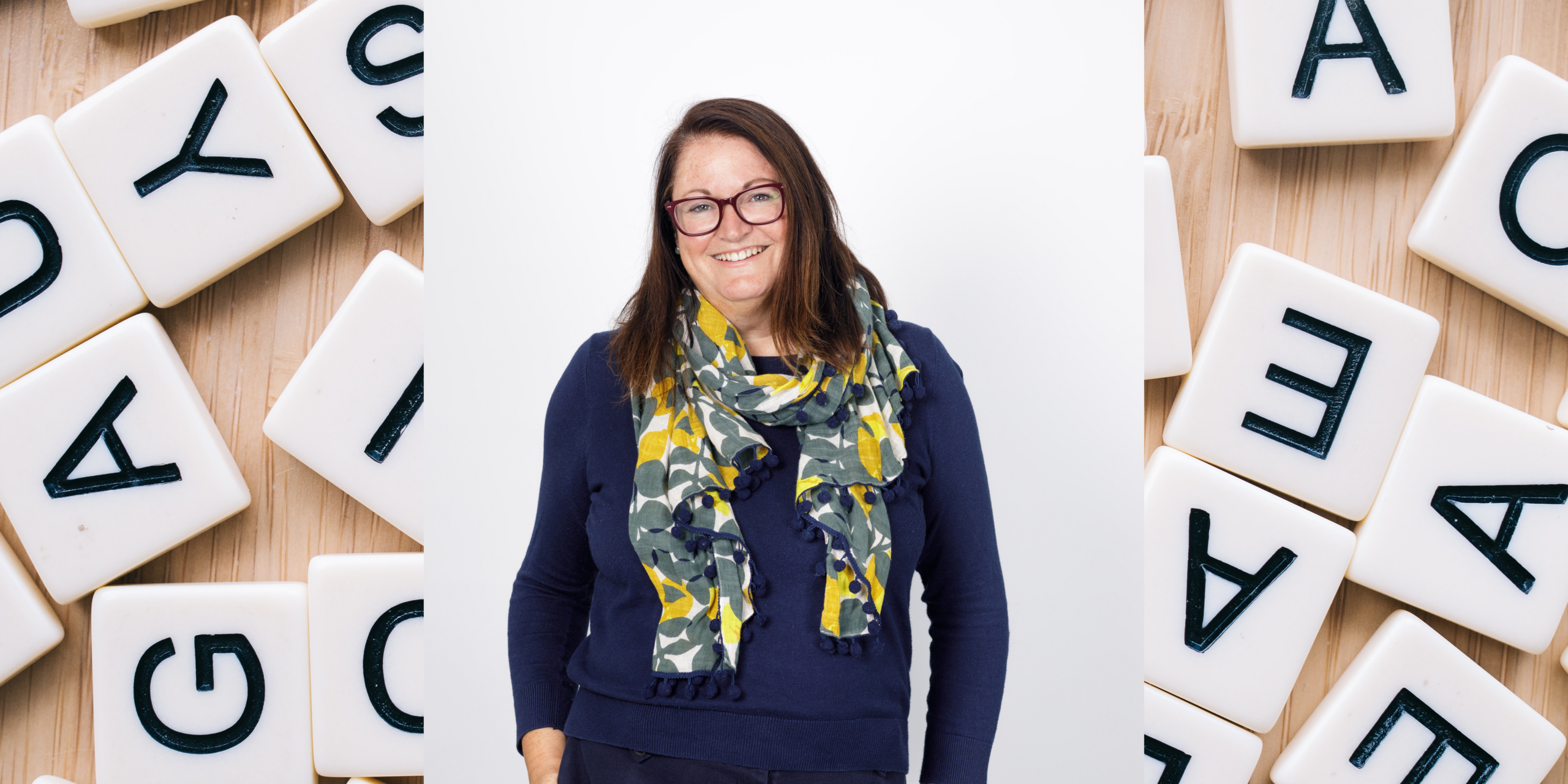 photo of Jacqui Wallis with letter tiles in the background to signify Dyslexia